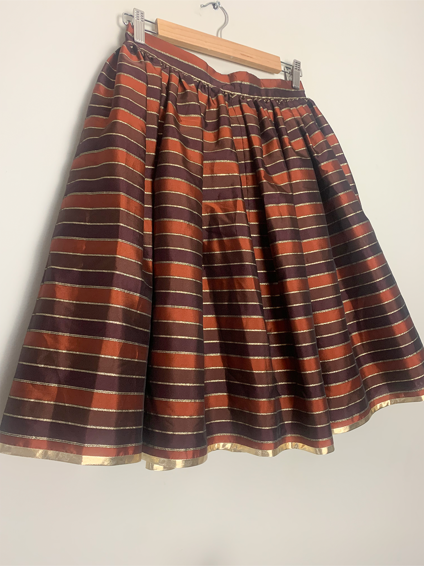 Jupe évasée avec plis et jupon satinée rayée tons marron et doré